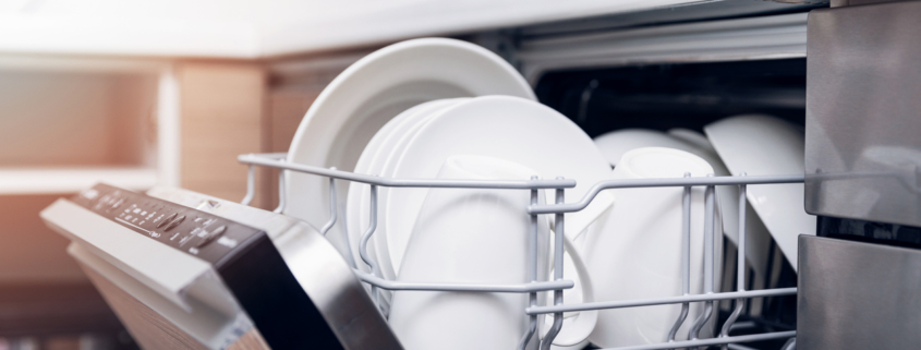 open dishwasher with clean dishes at home kitchen